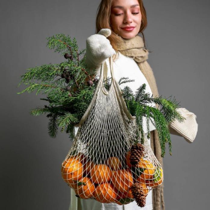Авоська с мандаринами и ветками хвои